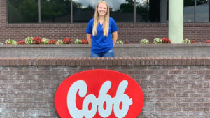 Sophie Chance standing behind the red and white Cobb sign